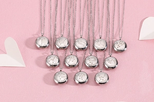 Vue détaillée de douze colliers du zodiaque en argent avec pendentifs ronds sur fond rose