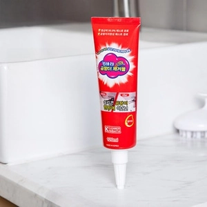 Detail of 120ml mold removal gel tube standing on a marble bathroom countertop