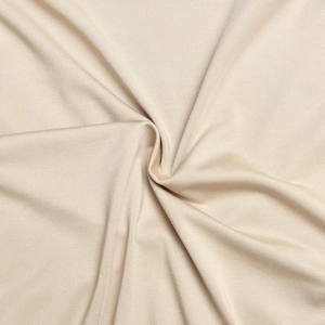 Close-up of beige fabric showing soft texture and pleated details of the elegant bodysuit