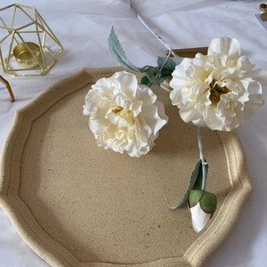 Detailed close-up of white artificial peonies on a tray for home decor photography