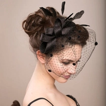 Side view of a vintage black fascinator hat with feathers and mesh net on a model