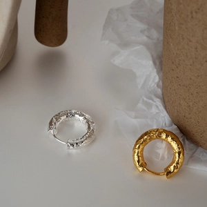 Detailed shot of gold and silver S925 sterling silver hoop earrings with lava texture surface