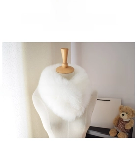 Detail view of a fluffy white faux fox fur scarf on a mannequin for winter styling