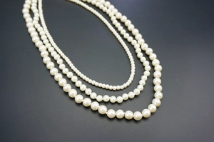 Detailed comparison of three tiered glass pearl necklaces with varying bead diameters