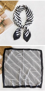 Detail of square silk scarf with black and white geometric chevron pattern and wide border