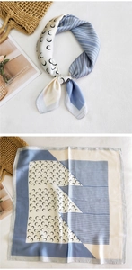 Detail of square silk scarf featuring moon prints and chic blue and white color block