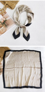 Detail of silk square scarf with champagne and black wave pattern and stylish border