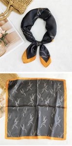 Detail of a square satin scarf with feather print and vibrant orange border accents