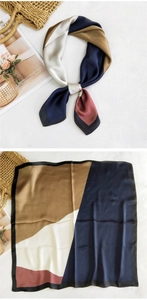 Detail of geometric pattern silk scarf showing chic color-block design and black hem edges