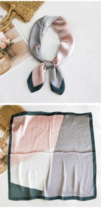 Detail showing geometric color-block silk scarf with pink and green panels on white fabric