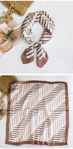 Detail of silk-texture square scarf with brown and white wavy patterns in flat lay view
