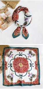 Detail of silk square scarf with vintage carriage print tied on a straw bag and flat lay view
