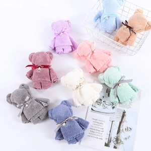 Creative coral fleece towels folded into bear shapes with pearl bows in various colors