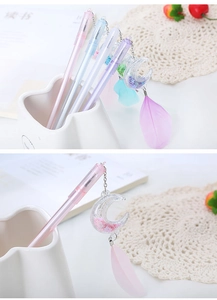 Detail showing moon pendant with flowing glitter and soft feather on creative gel pen