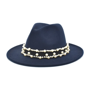 Detailed view of navy wool fedora with black ribbon and white faux pearl accents