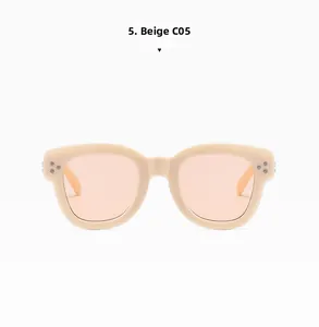 Close-up of beige retro sunglasses with translucent orange lenses and silver rivets