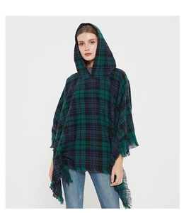 Detail of green and navy blue plaid hooded poncho with decorative fringe edges