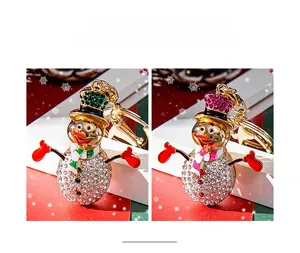 Detail of Christmas snowman keychains featuring white rhinestones and colorful enamel accents