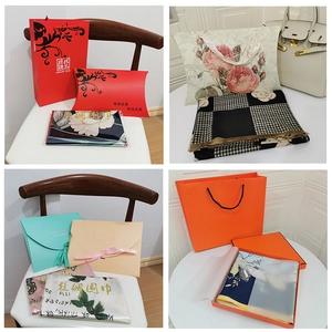 Detailed view of assorted silk scarves with elegant floral prints and gift packaging