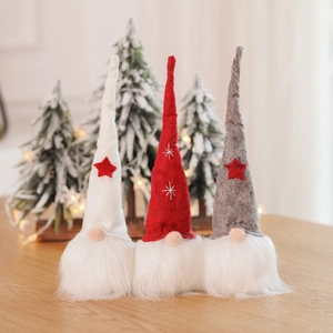 Three Christmas gnomes in red, white, and grey with felt hats on a wooden table