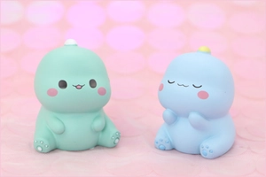 Detailed view of cute green and blue cartoon dinosaur figures for cake decoration