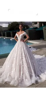 Detailed view of luxury bridal gown with 3D floral lace embroidery and fringe accents