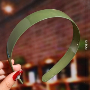 Detail of green plastic wavy headband with non-slip inner teeth and 13.5cm size mark