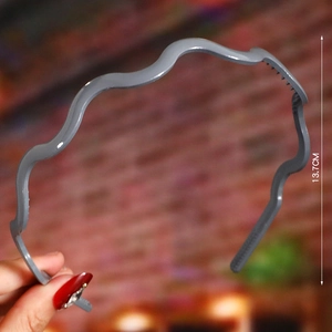 Detail view of grey wavy headband with non-slip teeth showing 13.7cm height measurement