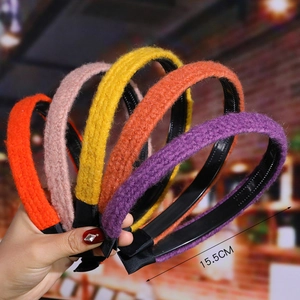 Detail of five colorful plush headbands in pink and orange measuring 15.5cm in diameter