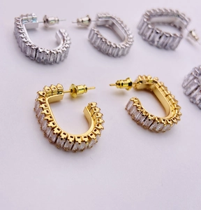Macro detail of French micro-pave square zircon hoop earrings in gold and silver finish
