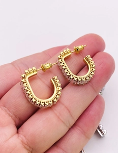 Macro shot of gold square zircon earrings with French micro-pave setting on 925 silver
