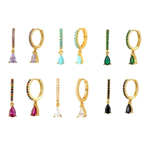 Macro view of gold plated huggie earrings with colorful teardrop zircon pendants