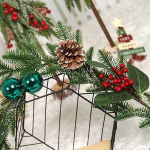 Christmas garland with peacock green balls, pine cones and red berries on iron frame