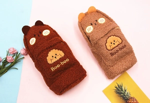 Close-up of caramel plush pencil cases with cute dog embroidery and fluffy texture