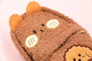 Close-up of brown teddy fleece animal pouch with cute embroidered face and ears