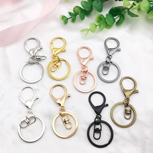 Lobster clasp and keyring sets in multiple finishes on white textured fabric background