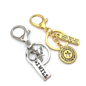 Close-up of gold and silver keychains with engraved inspirational quote tags