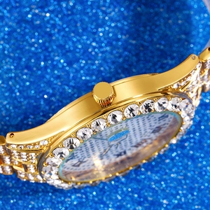 Elegant women's gold watch with sparkling rhinestones and Roman numeral dial on blue background