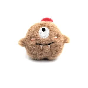 Cute Japanese style plush monster brooch with single eye and brown fur on white background