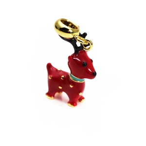 Macro shot of red enamel deer charm with golden antlers and dots for DIY jewelry