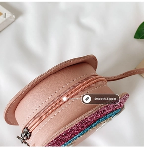Close-up of smooth metal zipper and colorful glitter finish on pink girls crossbody bag