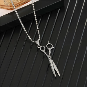 Detailed view of a silver scissor pendant on a bead chain necklace for men and women