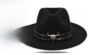 Detail of black felt jazz hat featuring a woven band and metal bull skull ornament