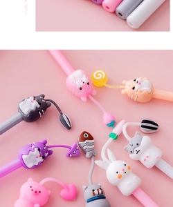 Close-up of cute cartoon animal gel pens with silicone toppers and charm pendants