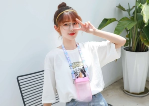 Pink popsicle shaped water bottle with colorful strap held by a person in a lifestyle setting