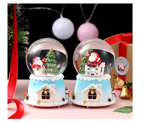 Detailed view of two Christmas crystal balls with Santa Claus and festive snowy bases