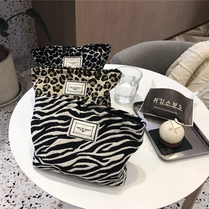 Three-piece leopard and zebra print canvas cosmetic bags set on a white table