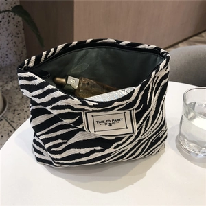 Detail of canvas leopard makeup bag with large opening and TIME TO PARTY label