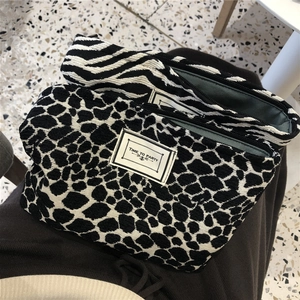 Close-up of zebra and leopard print jacquard makeup bags with metal zipper details