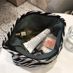 Top view of large capacity zebra print canvas cosmetic bag filled with various beauty products